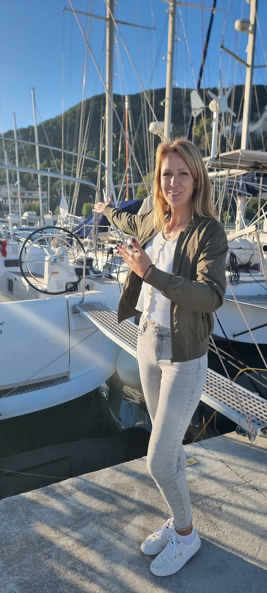 Laura zeigt in der Marina auf eine Charteryacht am Steg